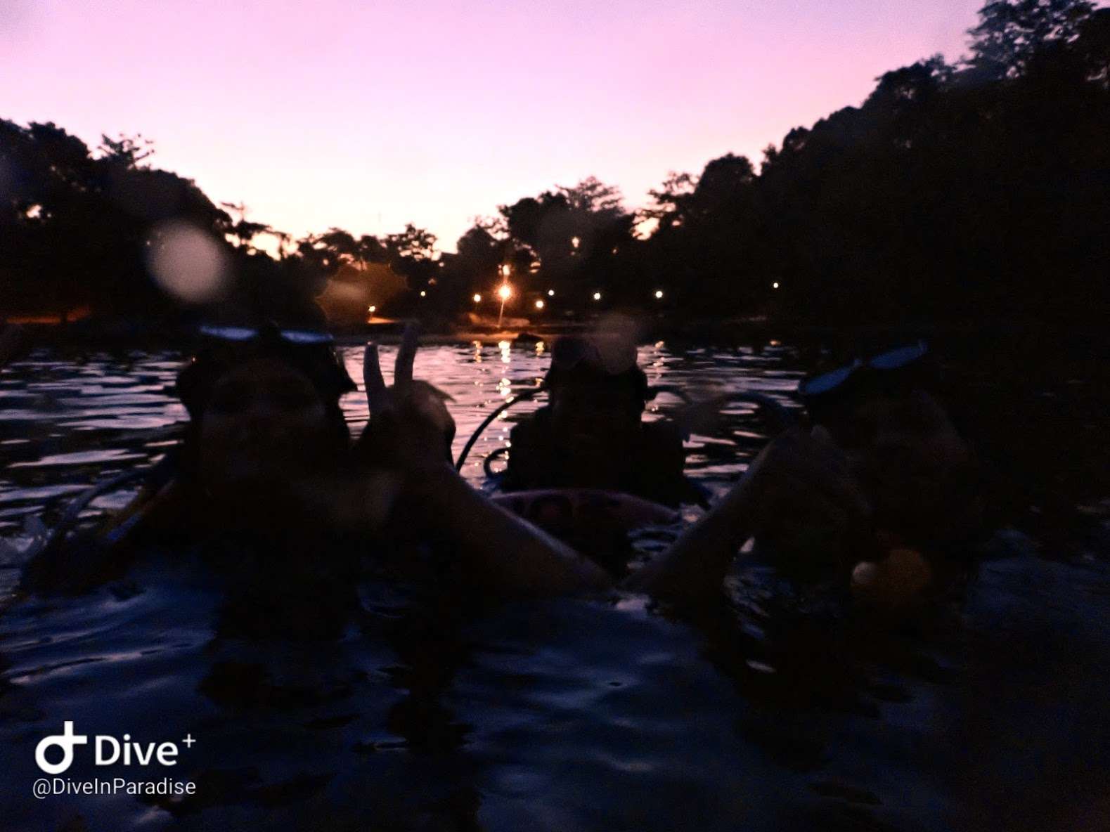 Divers entering the water for a shore dive at sunset in Phuket